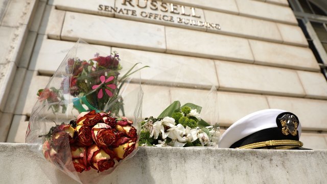 An impromptu memorial of flowers and a U.S. Navy officers hat stands outside of the Russell Senate Office Building.