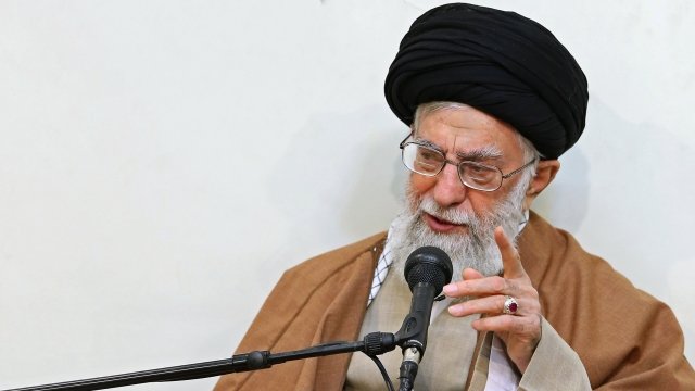 Ayatollah Ali Khamenei speaking into a microphone