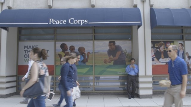 People walk on the street in front of the Peace Corps headquarters in Washington, D.C.