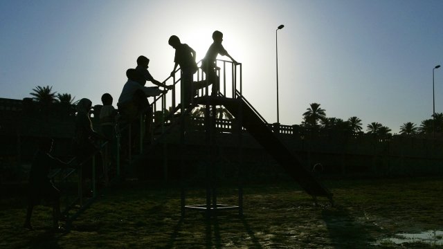 Iraqi children file up the stairs of a slide on a new playground July 2, 2004 in Baghdad, Iraq.