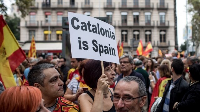 A woman holds up an anti-Catalan secession sign
