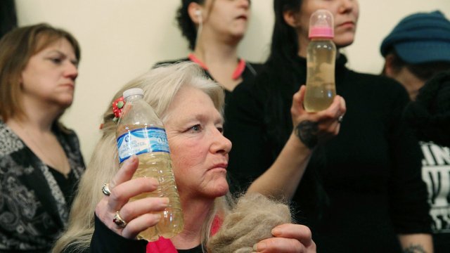 Flint residents hold bottles of contaminated water