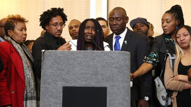 Stephon Clark's grandmother crying behind podium while surrounded by loved ones