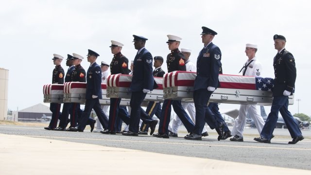 U.S. military carry the presumed remains of Korean War soldiers