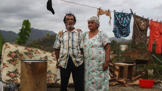 Puerto Rican residents stand outside their damaged home after Hurricane Maria