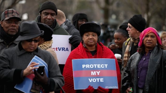 A woman holds a sign that says "protect my vote"