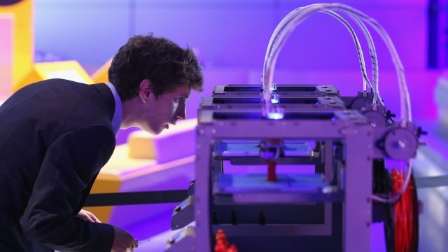 A technician looks at a 3D printer