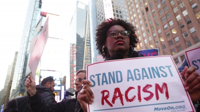 Woman holding anti-racism sign