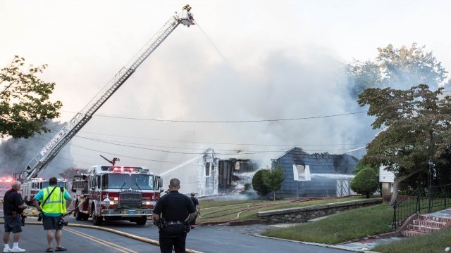 Firefighters douse a home in water