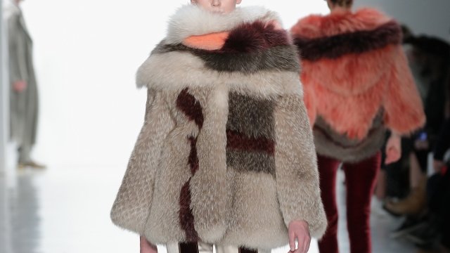 A model wears a fur coat on the runway