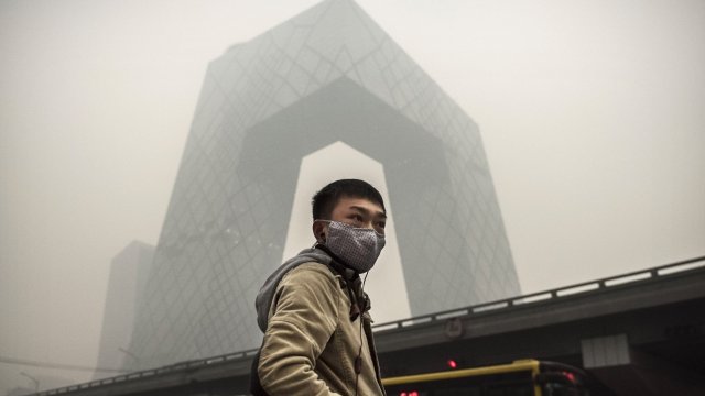 A man wearing a mask stands in polluted air in China