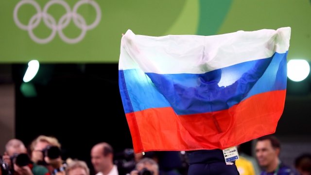 Russian athletes holds flag.