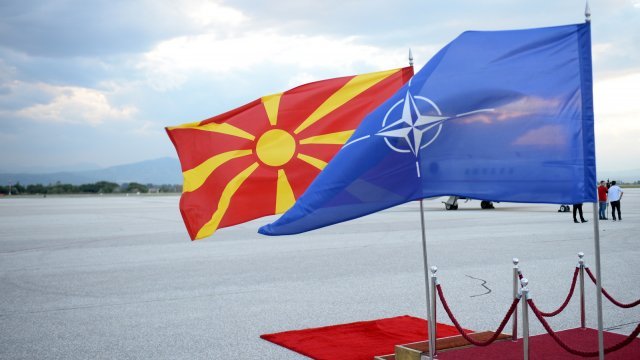 The Macedonian and NATO flags are show flying next to each other.