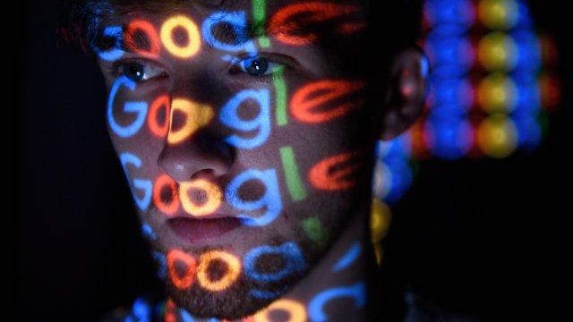 The Google logo is projected on a man's face