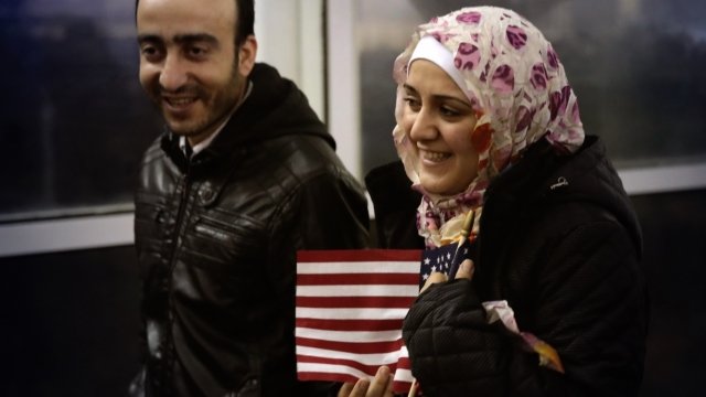 Syrian refugees Baraa Haj Khalaf clutches an American Flag as she leaves O'Hare Airport with her husband Abdulmajeed.