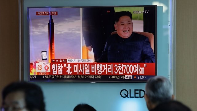 TV screen shows North Korean missile launch.