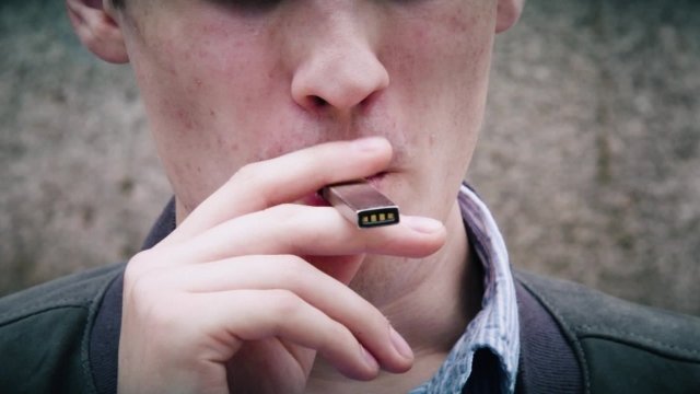 Young person uses a Juul e-cigarette