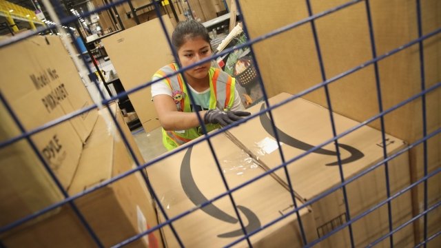 Workers pack and ship orders at an Amazon fulfillment center