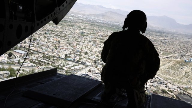 U.S. soldier sits out the back of a helicopter overlooking Kabul, Afghanistan