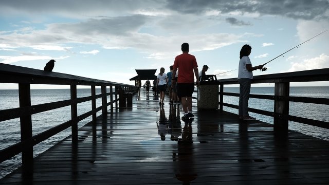 People walk along the Naples Pier i