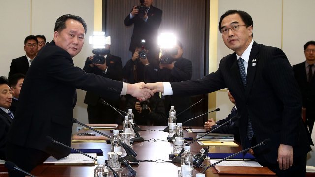 South Korean unification minister shakes hands with the head of the North Korean delegation.