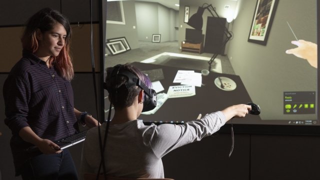 Stanford University researcher Fernanda Herrera, left, watches as fellow student navigates through the VR experience.