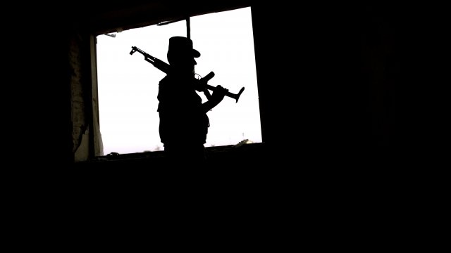 Afghan police officer secures a location following a Taliban attack in Kandahar, Afghanistan, in May 2011