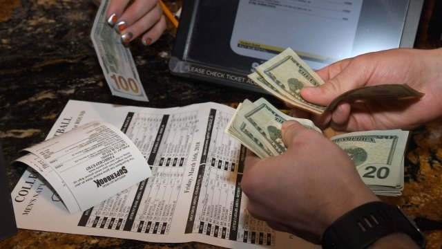 A man with cash in his hands making sports' bets in Las Vegas