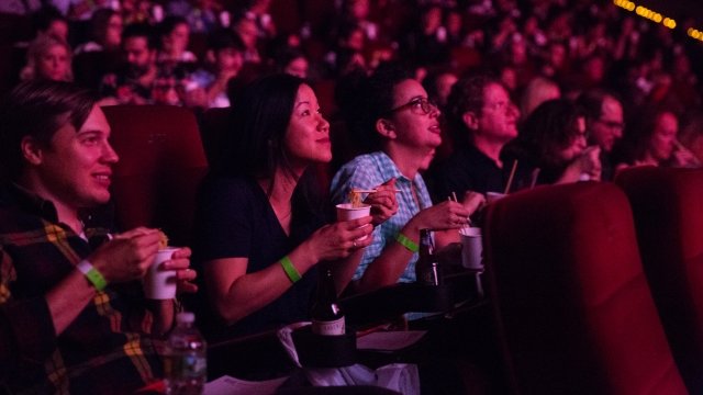 People eat noodles in theater.