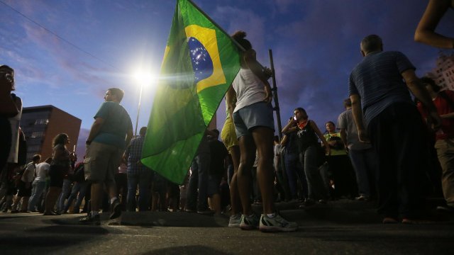 A protester holds a Brazilian flag