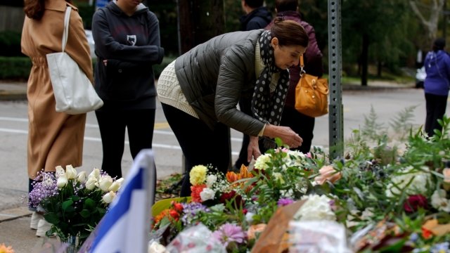Mourners lay flowers at the site of an anti-semitic mass shooting.