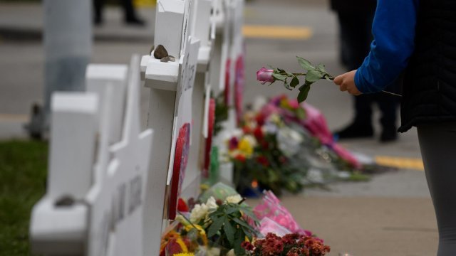 Mourner lays flower at memorial