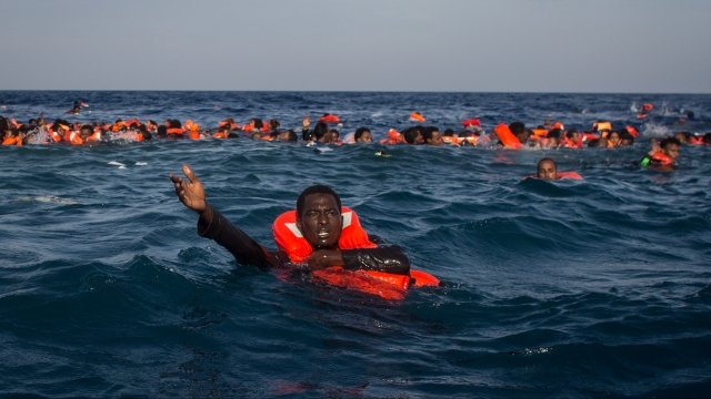 migrants are seen swimming and floating in the ocean after the boat they were in capsized.