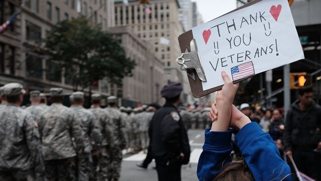 A girl holds up a sign thanking veterans at the nation's largest Veterans Day Parade in New York City.