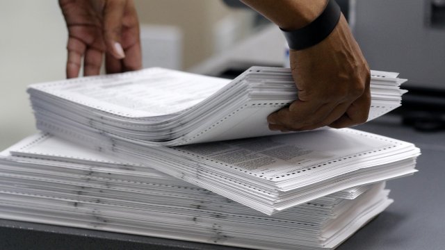 Person holds stack of ballots