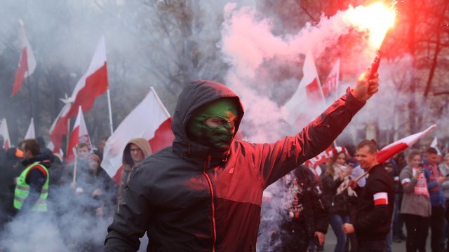 Masked person holds a lit flare at Poland's March of Independence on November 11, 2018.