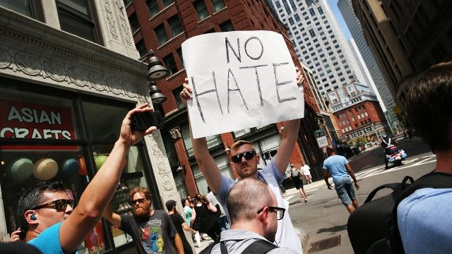 Man holds 'No Hate' sign.
