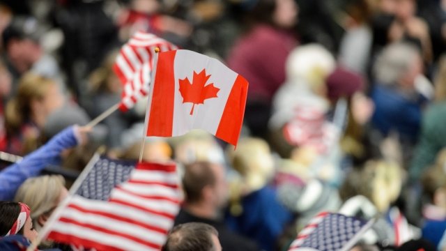 A Canadian flag waves amid a crowd of American flags