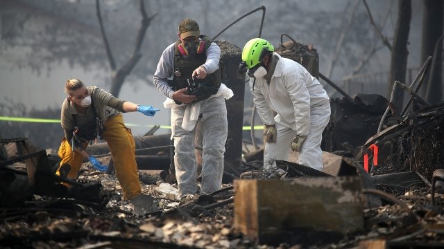 Rescue workers search an area where they discovered suspected human remains in a home destroyed by the Camp Fire.