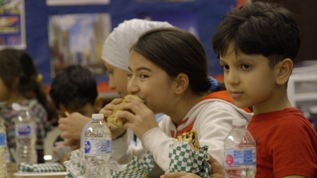 Young Syrian refugee kids in Chicago share a Thanksgiving meal.