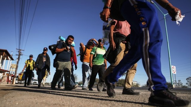 Migrants wait in line to get dinner in Tijuana, Mexico