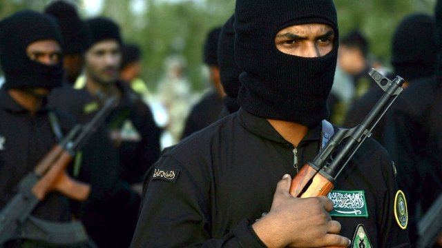 Saudi soldiers wearing black ski masks and holding AK-47 rifles