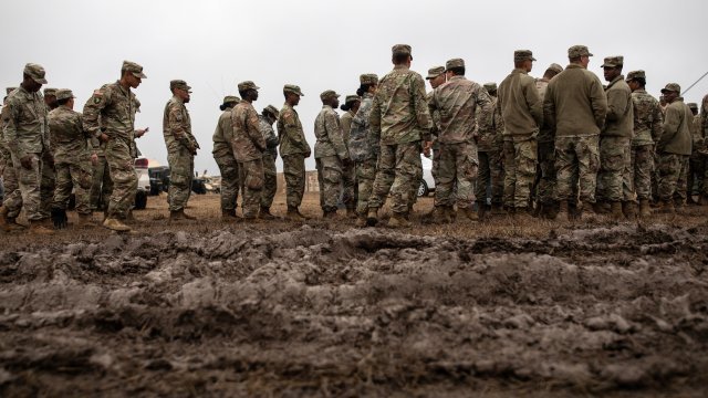 Troops stand in the mud