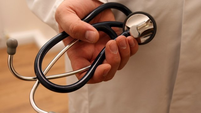 A hand holding a stethoscope