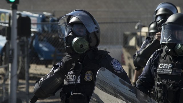 U.S. Customs and Border Protection agent wearing a gas mask.