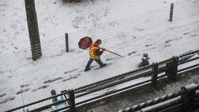 Construction worker carries stop sign