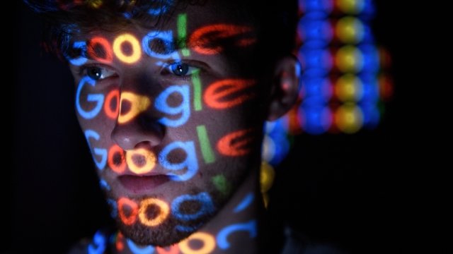 The Google logo is projected on someone's face