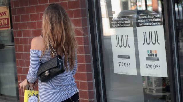 A woman walks in front of a smoke shop advertising Juul products in Chicago, IL