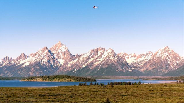 A plane flies above the Tetons in Grand Teton National Park.