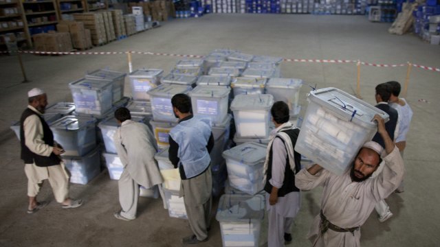 Men carry ballot boxes